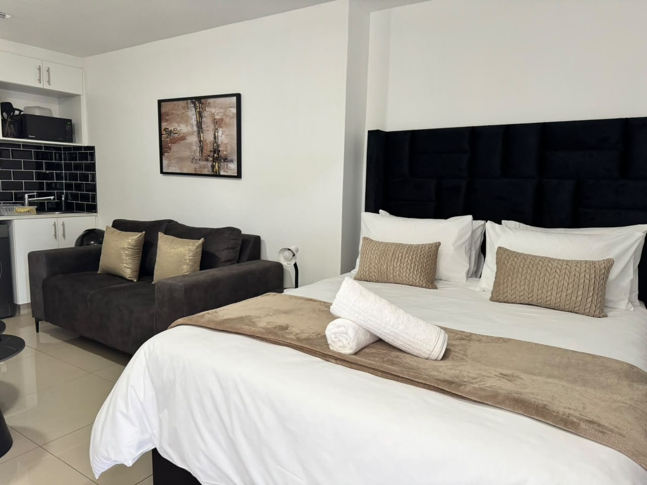 Bed, couch, and kitchen in Studio Sand